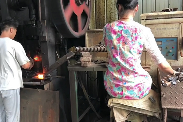 螺纹钢筋通过超音频9.1成人免费看片加热设备加热后 冲床锻压成螺母坯型